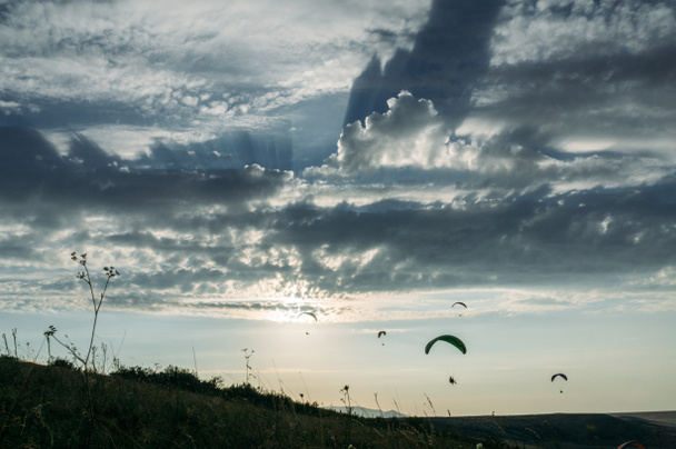 Parachutists gliding in blue sky over scenic landscape of Crimea, Ukraine, May 2013 - Photo, Image