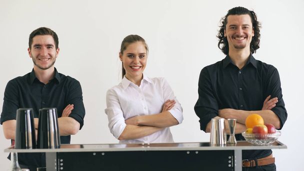 Professinal bartender man and woman smiling at mobile bar table on white background studio - Foto, Bild