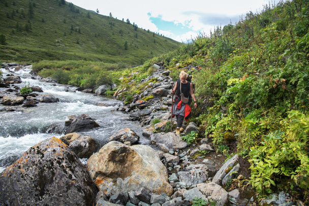 jonge backpacker wandelen in de buurt van rivier in Altai, Rusland - Foto, afbeelding