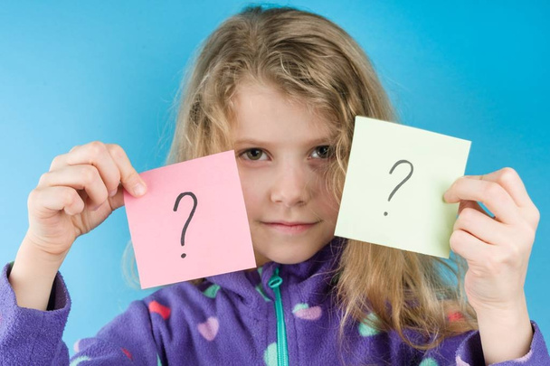 Girl holding stickers with question marks, Blue background - Fotó, kép