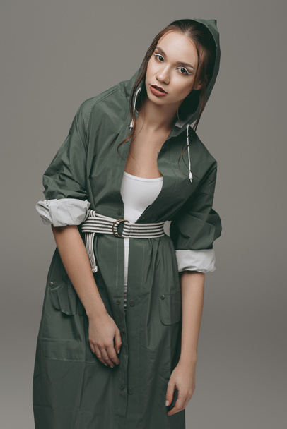 stylish girl posing in green autumn raincoat, isolated on grey - Photo, Image