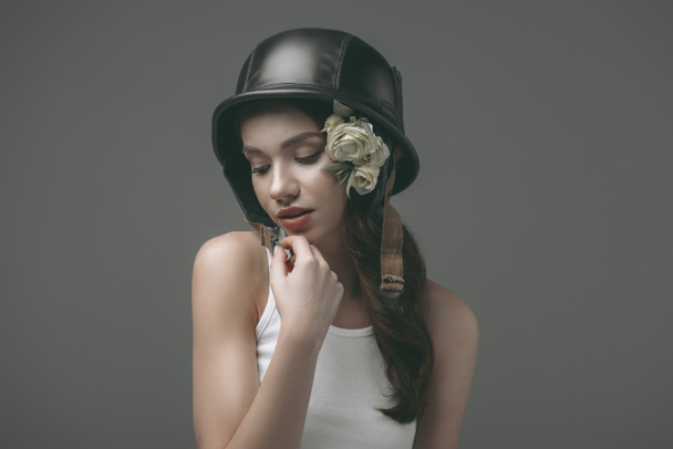 krásná nabídka mladá dívka v vojenská helma s květinami, izolované Grey - Fotografie, Obrázek
