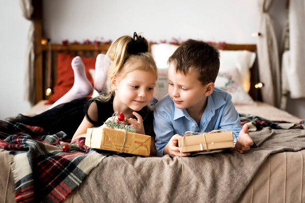 Girl and boy open gifts. Merry Christmas and Happy Holidays. - Foto, Bild