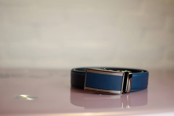 Cintura da uomo in pelle blu su un tavolo di vetro
 - Foto, immagini