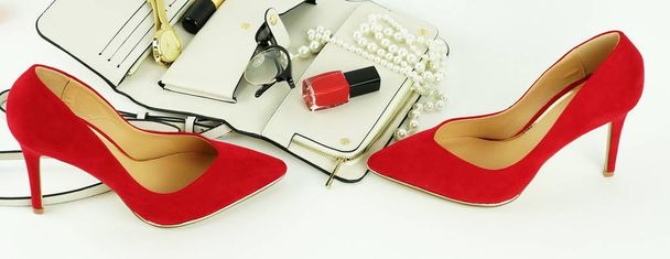 Female fashionable stylish accessories and cosmetics. red shoes with heels, white bag, watch, glasses, lipstick, mascara, red nail polish on a white background. Beauty blog concept. Copy space - Foto, Imagem