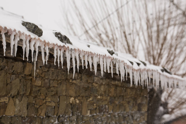 Zmrazené střešní rampouchy v zasněžený den - Fotografie, Obrázek