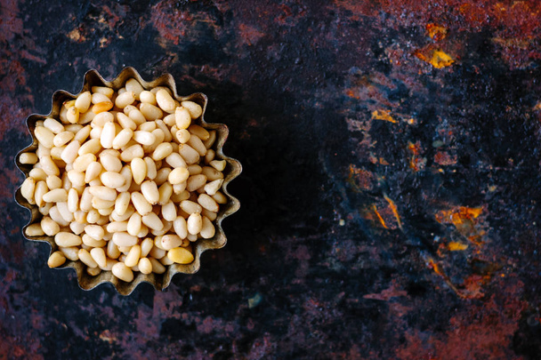 Top view of pine nuts over the rusty background - Photo, image
