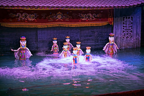Show de marionetas de agua en Vietnam bajo luces púrpuras
 - Foto, imagen