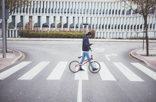 Мужчина BMX всадник на улице с телефоном
 - Фото, изображение