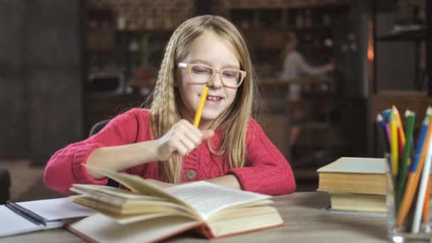 Chica alegre escribiendo su tarea para la escuela
 - Imágenes, Vídeo