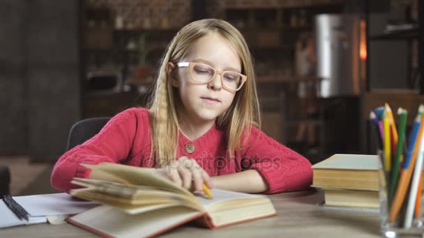 Χαμογελώντας εφηβικό κορίτσι που μελετούν τα μαθήματα στο σπίτι - Πλάνα, βίντεο