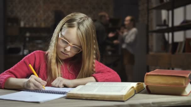 Smutna dziewczyna studiuje, podczas gdy jej rodzice walki - Materiał filmowy, wideo