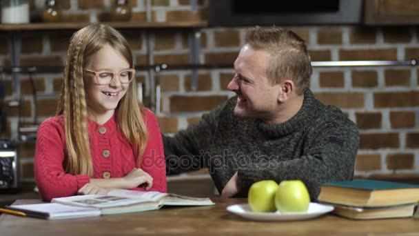 Sinkku isä auttaa tytärtä kotitehtävissä kotona
 - Materiaali, video