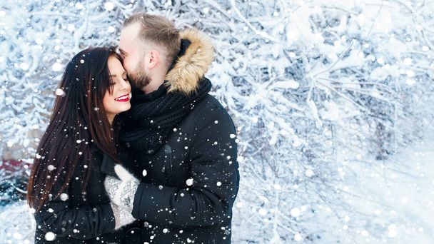 Happy Young Couple in winter snow park hugging .Family Outdoors. - Φωτογραφία, εικόνα