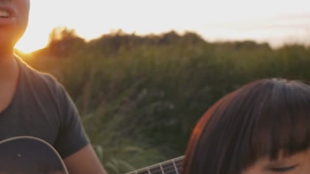 Man en vrouw zingen een lied met een gitaar - Video