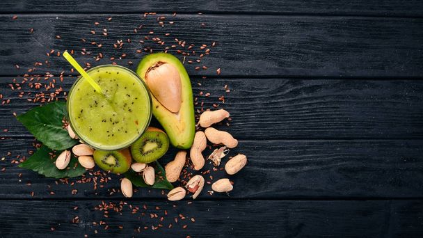 Kiwi smoothie and avocado with flaxseed and nuts. On a wooden background. Top view. Free space for your text. - Foto, imagen