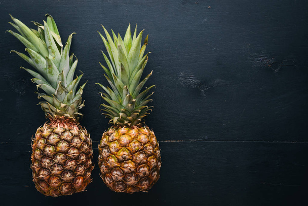 Pineapple on a wooden background. Top view. Free space for text. - 写真・画像
