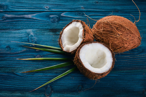 Coconut on a wooden background. Tropical fruits and nuts. Top view. Free space for text. - 写真・画像