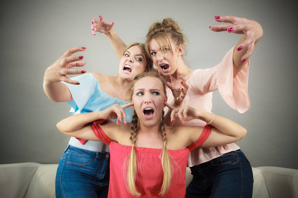 Woman being bullied by two females - Foto, afbeelding