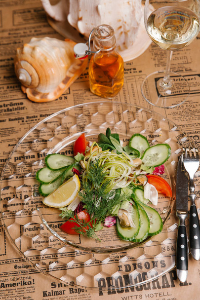 Salade de légumes aux concombres, poireaux, olives, thon et oeufs de caille servis dans une assiette en cristal
 - Photo, image