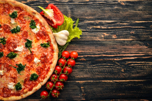 Neapolitan Pizza. Spinach, gorgonzola cheese, sausage salami. On a wooden background. Top view. - Φωτογραφία, εικόνα
