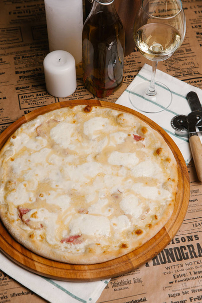 pizza au fromage avec mozzarella et jambon servi sur une planche en bois
 - Photo, image