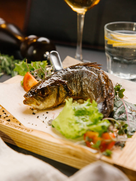 Ahşap tahta üzerinde ızgara balık sebze ve otlar ile servis - Fotoğraf, Görsel