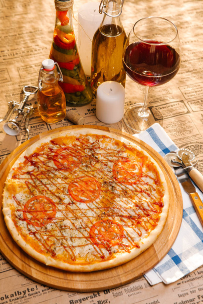 Chicken pizza with mozzarella, tomatoes and ketchup on top served on wooden board - Photo, Image