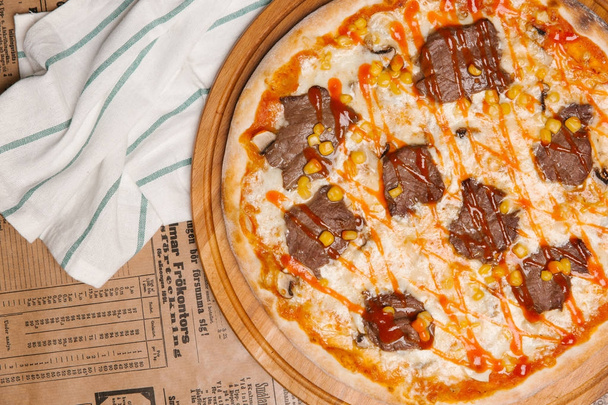 Sığır eti barışlar, mısır tohumları ve domates sosu üstüne lezzetli pizza - Fotoğraf, Görsel
