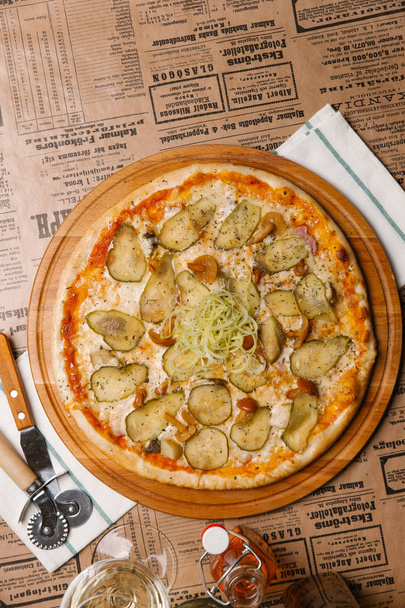 Pizza mit Essiggurken, Pilzen und Lauch auf Holzbrett serviert - Foto, Bild