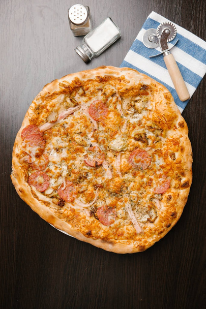 Pizza con pepperoni, jamón, champiñones y queso
 - Foto, imagen