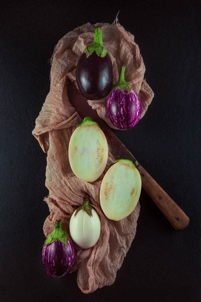 Fresh, beautiful colorful eggplants decorated on plates and napkin, studio shoot can be used as background - Photo, Image