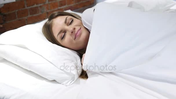 Snící mladá žena spí v posteli v noci - Záběry, video