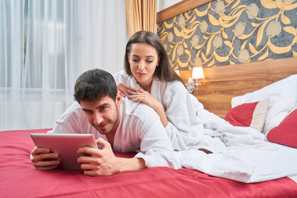 hotel, travel, relationships, and happiness concept - happy couple in bed - Fotografie, Obrázek