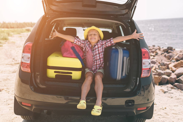 Travel, tourism - Girl with bags ready for the travel for summer vacation. Child going on Adventure. Car travel concept - Foto, Imagen