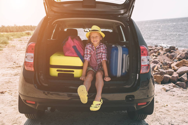 Travel, tourism - Girl with bags ready for the travel for summer vacation. Child going on Adventure. Car travel concept - Фото, изображение