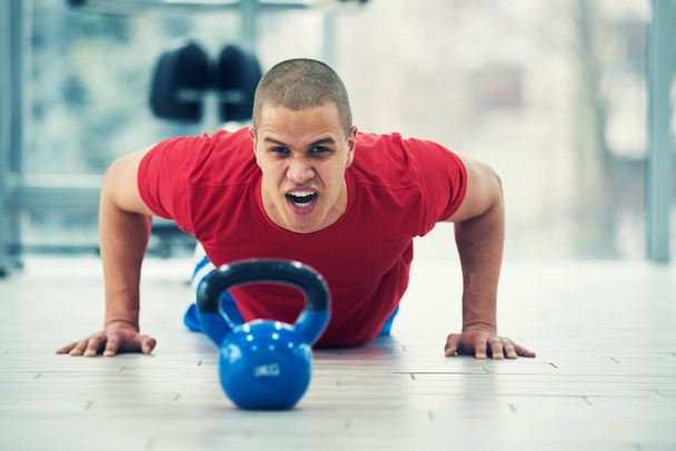 Young fitness man training by kettlebell. - Foto, immagini