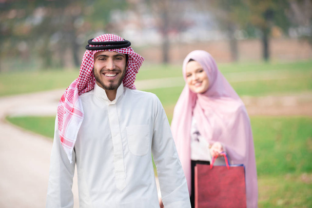Lovely muslim couple taking a walk after shopping. concept - 写真・画像