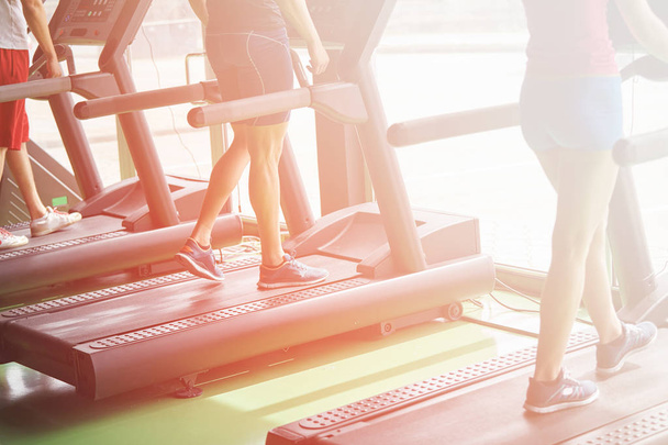 People running in machine treadmill at fitness gym club - Foto, Imagen