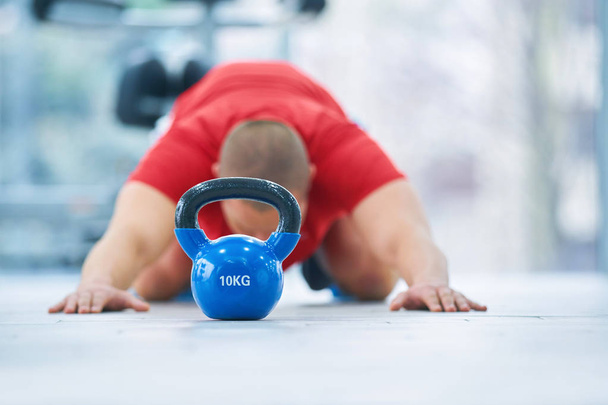 Young fitness man training by kettlebell. - Foto, immagini