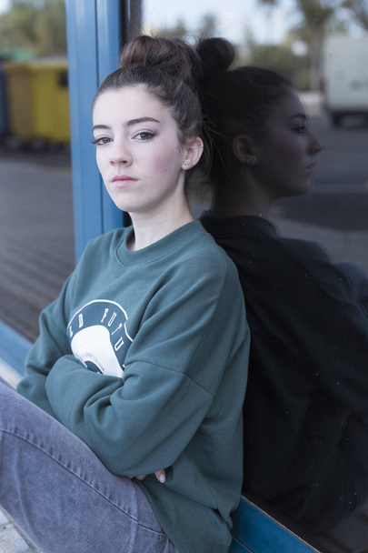 Adolescente assise regardant vers la caméra
.  - Photo, image