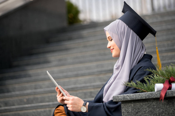 Pretty  female graduate student wearing hijab with computer - Foto, Bild