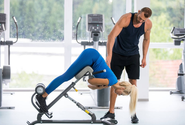 personal trainer working with young woman in the gym  - Φωτογραφία, εικόνα