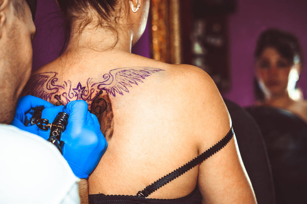 mestre tatuagem mulher em suas costas
 - Foto, Imagem