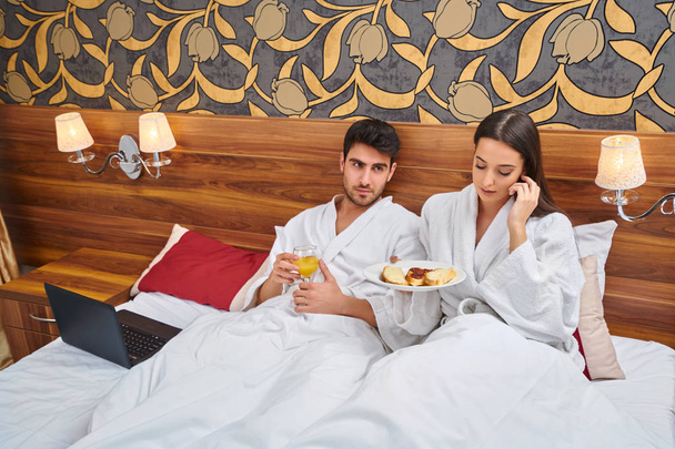 hotel, travel, relationships, and happiness concept - happy couple in bed - Fotografie, Obrázek