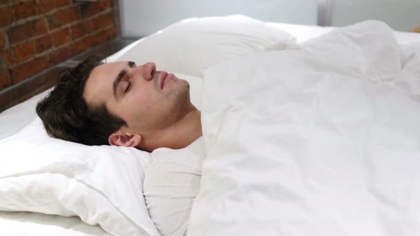 Νεαρός άνδρας που κοιμάται στο κρεβάτι τη νύχτα - Πλάνα, βίντεο