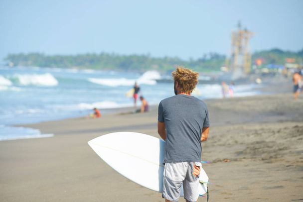 A surfer with his surfboard go  to the waves - Foto, Imagen