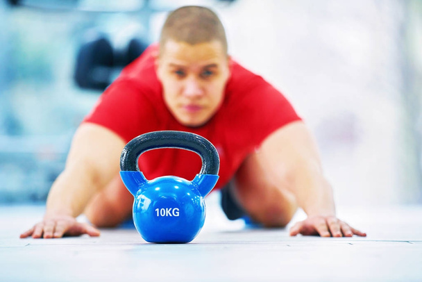 Young fitness man training by kettlebell. - Foto, Bild