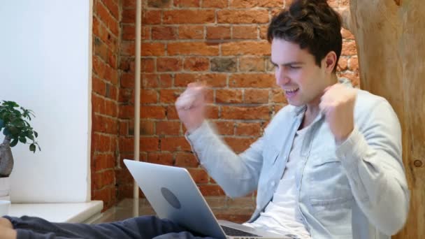 Szczęśliwy człowiek świętuje sukces podczas pracy na laptopie - Materiał filmowy, wideo
