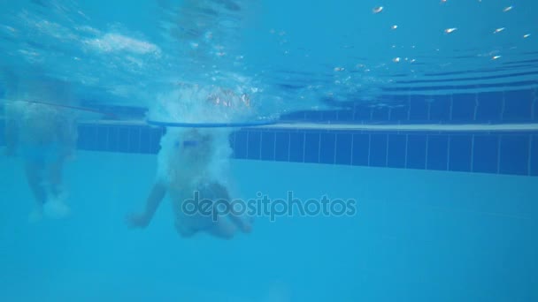 gyerekek úszni a medencében, 4k a víz alatti fotózáshoz - Felvétel, videó